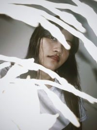 Portrait of young woman holding cigarette on bed