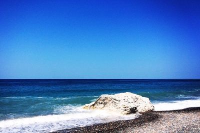 Scenic view of sea against clear blue sky
