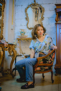 Girl looking away while sitting on chair