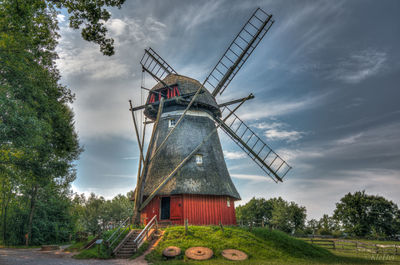 Traditional windmill on field against sky