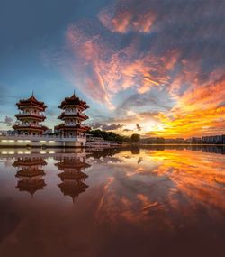 Reflection of building on lake during sunset