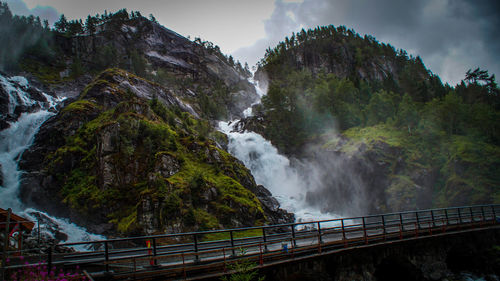 Scenic view of waterfall against sky
