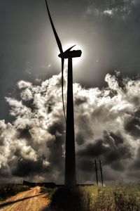 Traditional windmill on field against cloudy sky