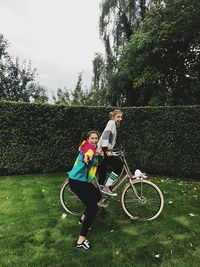 Mother and daughter with bicycle on tree