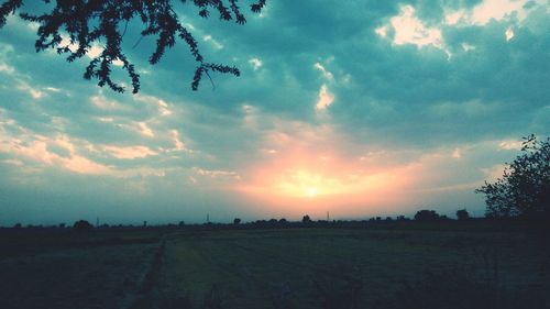 Scenic view of field against cloudy sky