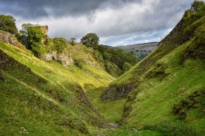 Scenic view of land and mountains against sky