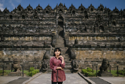 Portrait of woman standing outside temple