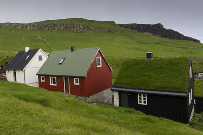 Small faroe islands dwellings including a traditional turf roofed house in rural landscape