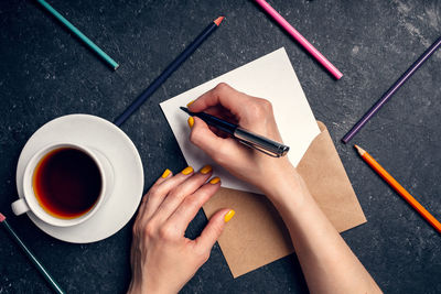 A woman writes plans for 2022 on black background top view