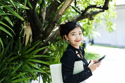  woman in a black dress holds a laptop computer. the concept of young entrepreneurs.