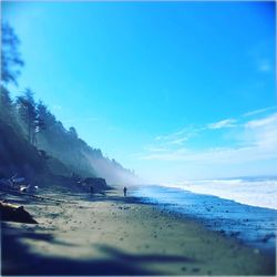 Scenic view of beach against blue sky