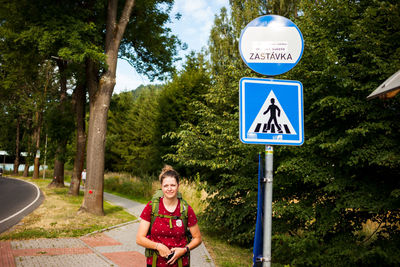 Portrait of young woman by road signs