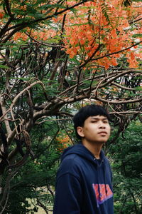 Young man looking away in forest