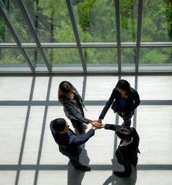 High angle view of business people staking hands at office