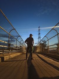 Rear view of man on bridge against sky