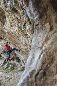 Climber begining a hard sport climbing route in a cave.