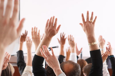 Cropped image of hands raised at seminar