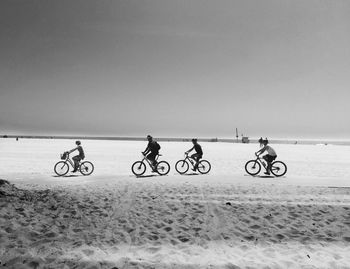 Bicycles on beach against clear sky