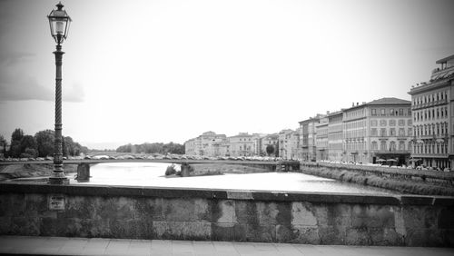 Bridge over river against buildings in city