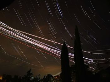 Low angle view of light trails against sky at night