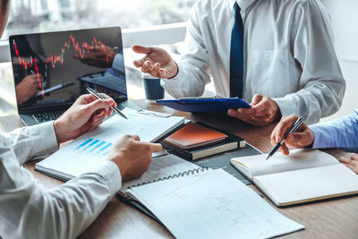 Midsection of business colleagues working at desk in office