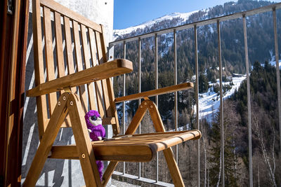 Soft plush toy enjoying sunlight on chair in balcony at resort