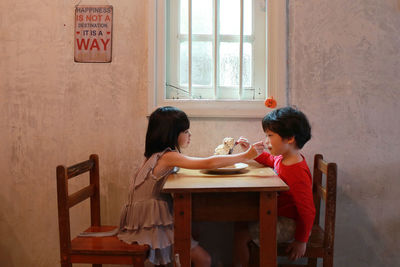 Siblings eating at table