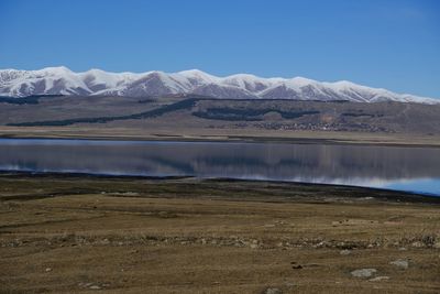 Scenic view of lake and mountains against clear sky