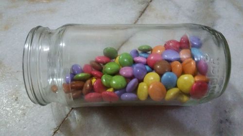 High angle view of multi colored candies in bowl on table