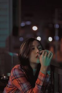 Young woman on balcony at night