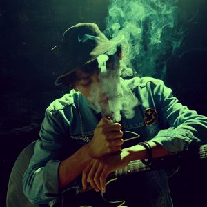 Man holding cigarette against black background