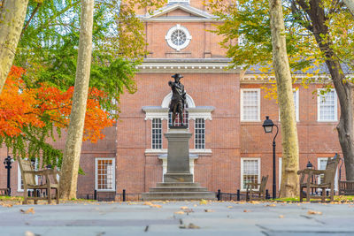 Statue against trees and building during autumn