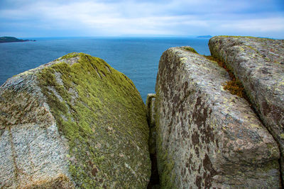 Close-up of rocks in sea against sky