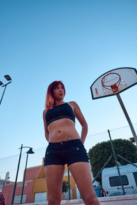 Girl with red hair on a basketball court. outdoor sports concept