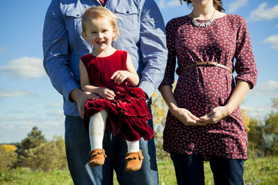 Young pregnant couple holding daughter in detroit mi