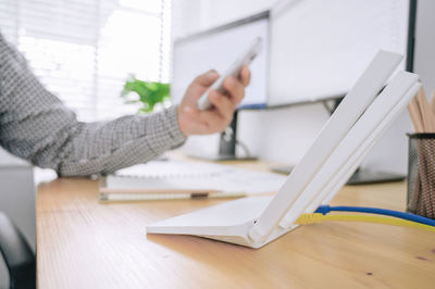 Close-up of man using laptop on table