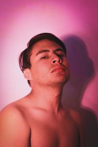 Portrait of young man looking away against wall