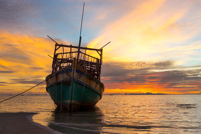 Ship in sea against sky during sunset