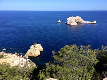 High angle view of rock formation in sea against clear sky