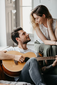 Young man playing guitar at home