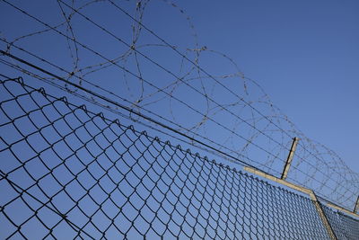 Low angle view of barbed wire against clear sky