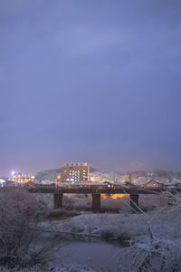 Illuminated buildings against sky during winter