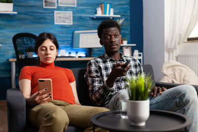 Portrait of smiling friends sitting at home