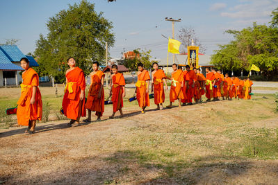 Rear view of people against orange sky