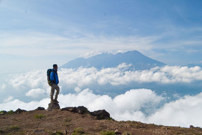 Man standing on mountain against sky