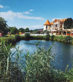 Houses by lake against sky