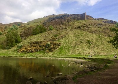 Scenic view of lake by mountain against sky