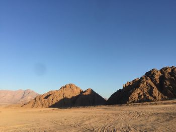 Scenic view of desert against clear blue sky