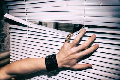 Cropped hand touching blinds