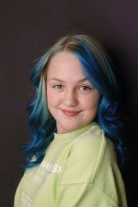 Portrait of young woman against black background